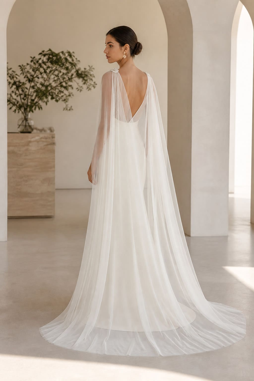 Anais Sheer Bridal Cape — editorial in-context view showing weightless bridal tulle with discreet shoulder fastenings and a clean edge
